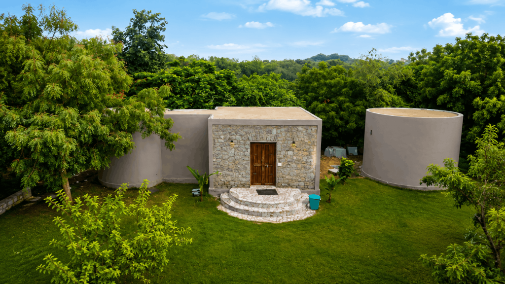 Luxury stone cottage surrounded by lush green gardens at Thour Nature Resorts, Jawai Bandh, Rajasthan